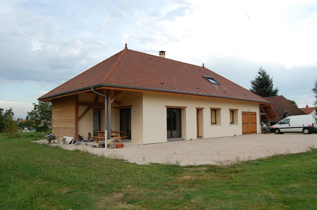 Construction d'une maison en bois et paille. Vue extérieure façade avant.