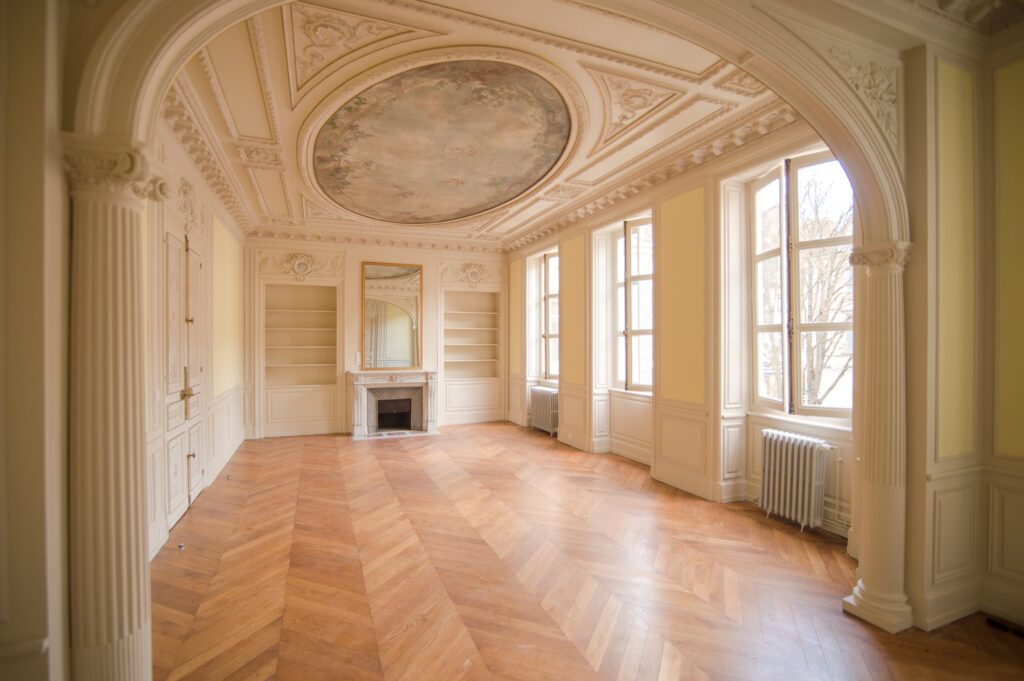 Restauration d'un hôtel particulier en 20 logements à Chalon-sur-Saône. Vue intérieure d'un logement rénové, séjour salon avec parquet massif et plafond mouluré