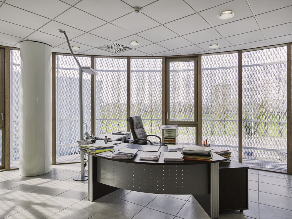 Extension du comptoir des fers à Chalon-sur-Saône par Naos Atelier d'Architecture. Vue d'intérieur d'un bureau, mur extérieur entièrement vitré.