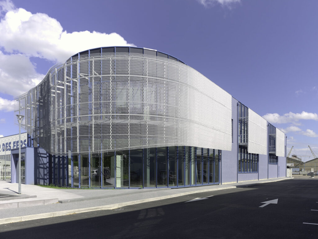 Extension du comptoir des fers à Chalon-sur-Saône par Naos Atelier d'Architecture. Vue extérieure du bâtiment, résille métallique en façade